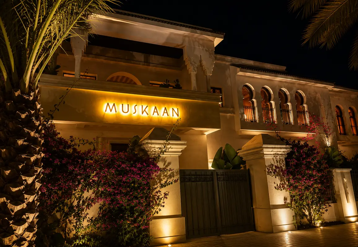 Façade illuminée de la villa du restaurant Muskaan à Hay Riad, Rabat, entourée de bougainvilliers