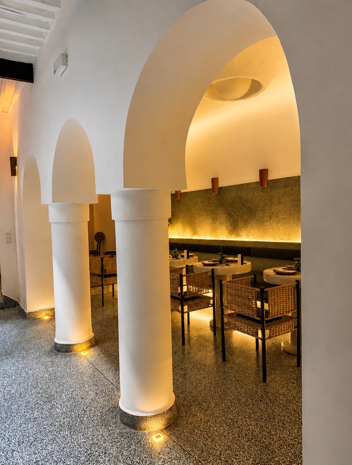Salle aux arches blanches et banquettes de NBTA