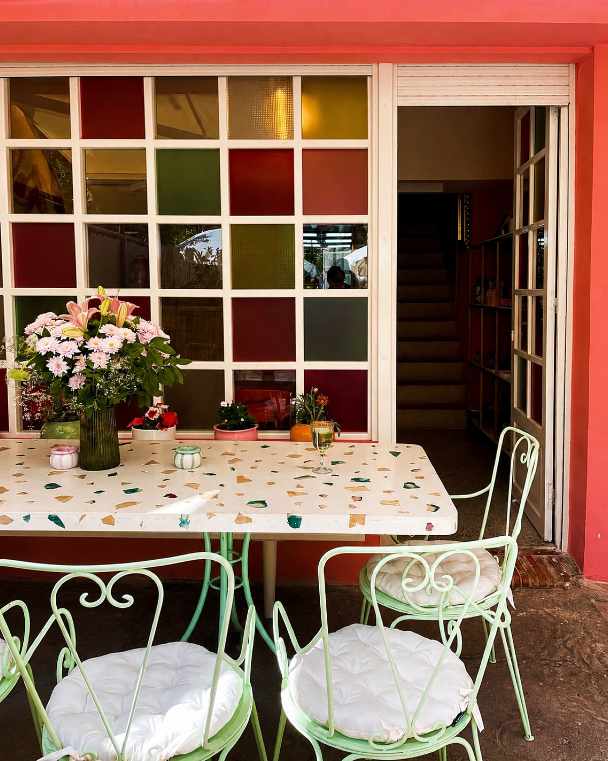 Terrasse sous verrière du café-restaurant Niya à Casablanca, chaises vert menthe et murs rose poudré