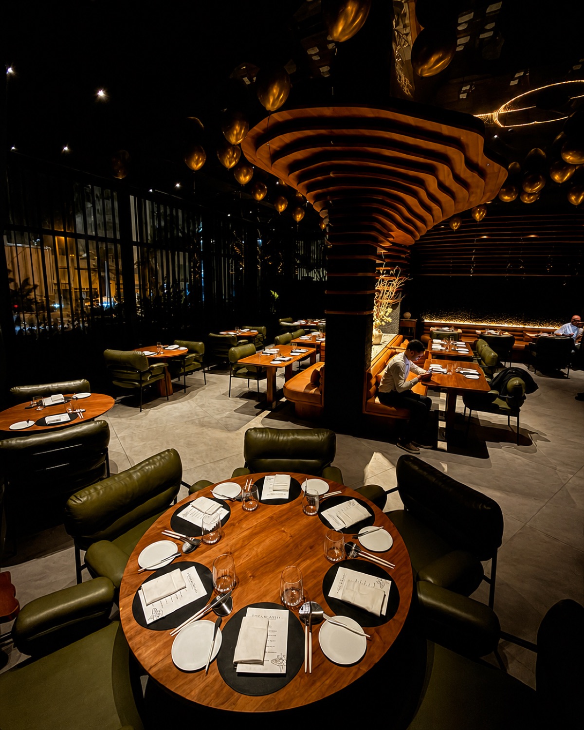 Salle du restaurant Table 3 à Casablanca : plafond de bois sculpté et fauteuils vert olive