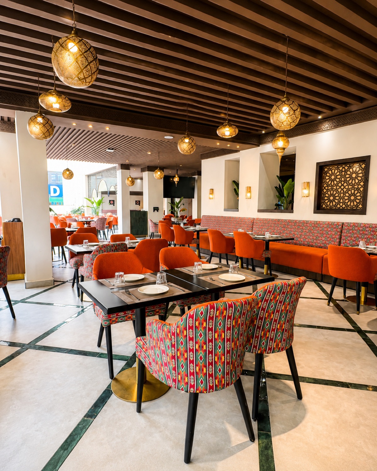 Salle de Michwate Fès : fauteuils orange, coussins en kilim et lanternes
