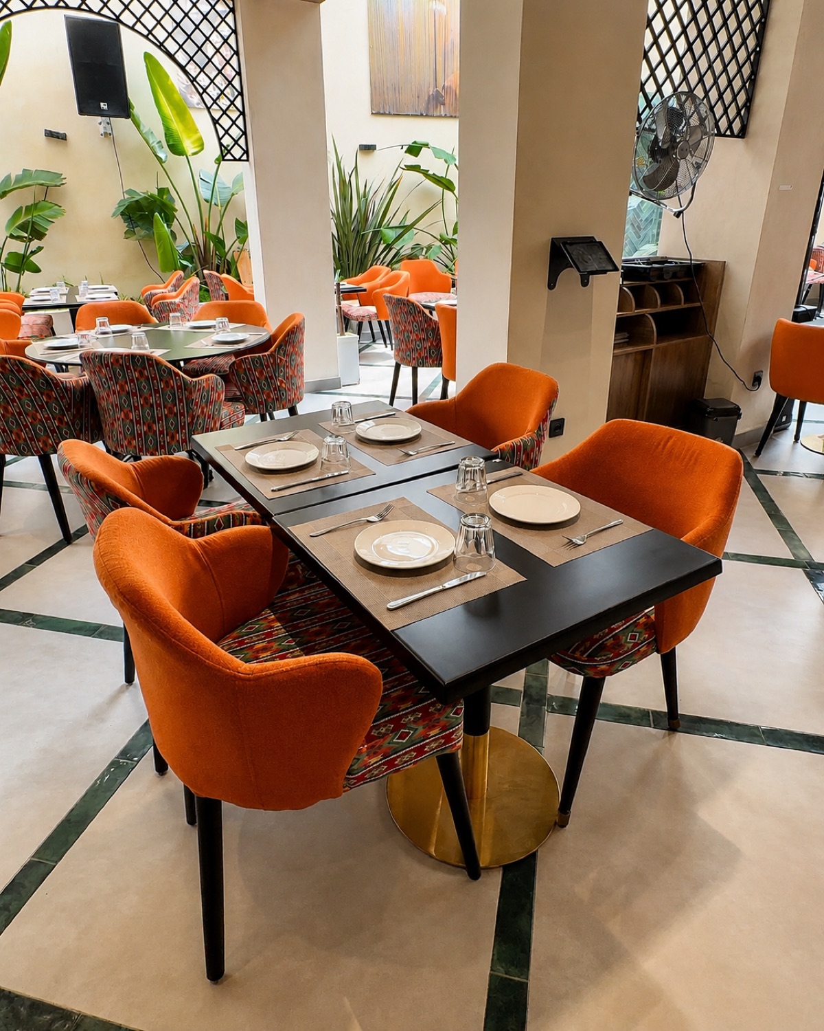 Table dressée aux fauteuils orange chez Michwate Fès